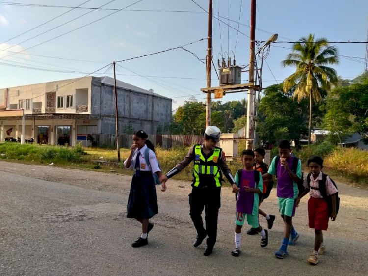 Senyum Manis Sejukkan Hati, Polwan Satlantas Polres TTU Peduli Keselamatan Seberangkan Pelajar di Pagi Hari.
